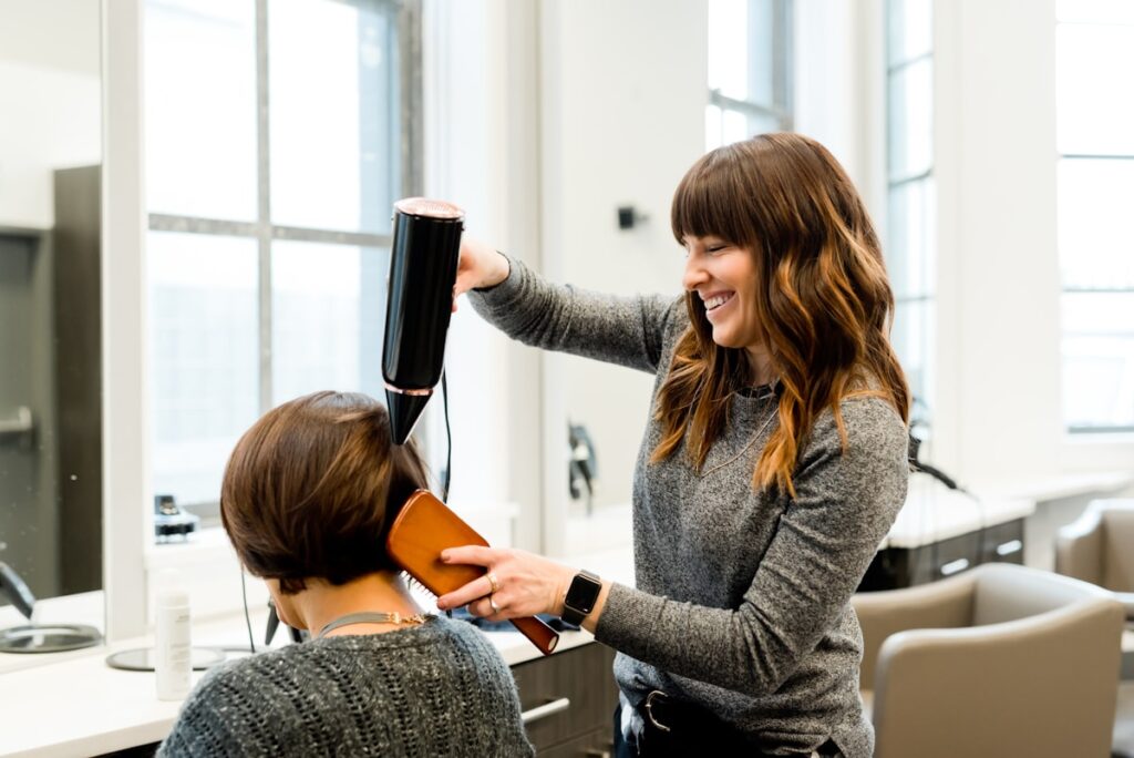 Hair stylist coloring and styling a client's hair at a hair salon in Bucharest